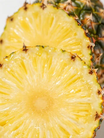 Verse, gesneden ananas op een rustieke houten tafel