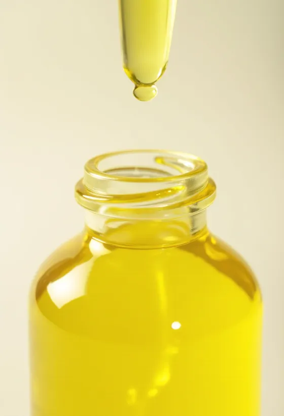 Flesje citroenolie met verse citroenschijfjes en zest