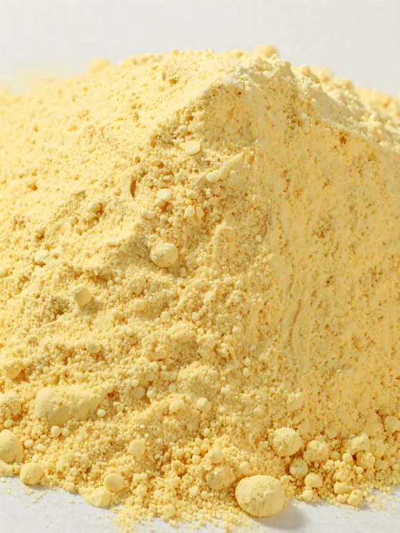 Maïsmeel in een keramische kom, geel poedervormig meel op een houten oppervlak