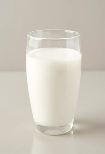 Een glas en een fles verse melk op een licht aanrecht, zonder dieren