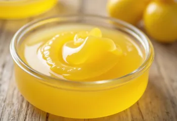 Ghee in pot en op lepel op houten plank, natuurlijk licht