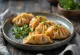 Gyoza met sojasaus geserveerd, versierd met verse groene ui
