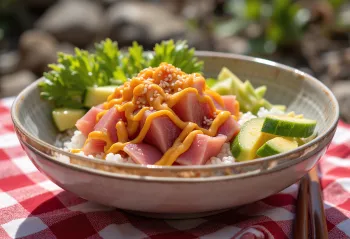 Poké bowl geserveerd met verse tonijn, avocado, sesamzaad en srirachasaus