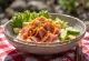 Poké bowl geserveerd met verse tonijn, avocado, sesamzaad en srirachasaus