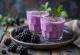 Kefir met zwarte bessen geserveerd in glazen, met verse bessen