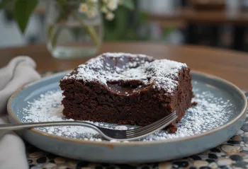 Kladdkaka met chocolade, geserveerd met poedersuiker en stukjes chocolade