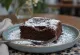 Kladdkaka met chocolade, geserveerd met poedersuiker en stukjes chocolade