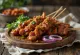 Suya met pinda-kruidenmengsel, gegrild vlees geserveerd