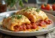 Stromboli met tomatensaus geserveerd, rijkelijk belegd met tomatensaus en gesmolten mozzarella, knapperig van buiten en zacht van binnen.