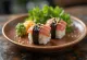 Omusubi met tonijn en mayonaise, geserveerd met nori en sesamzaad