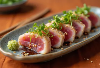 Katsuo tataki met wasabi, plakjes tonijn gegarneerd met sesamzaad en bosui