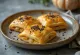 Samsa met pompoen, goudbruin, in knapperig deeg, geserveerd met verse koriander