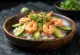 Chirashi met garnalen, sushirijst, avocado en sesamzaad geserveerd