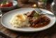 Rundergoulash geserveerd met aardappelpuree