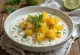 Tinda dahi, met yoghurt en koriander, versierd met vers limoenblad